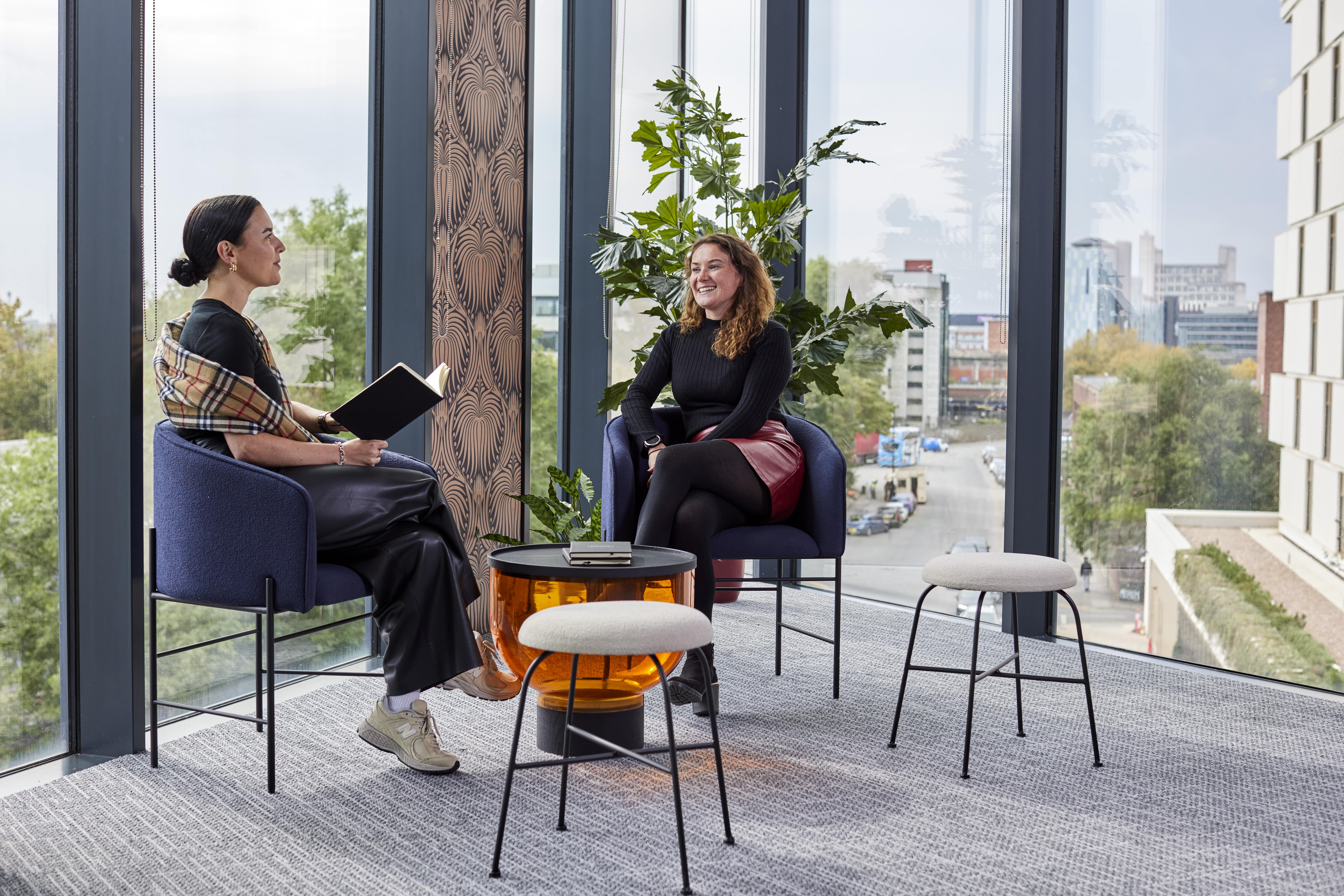 a relaxed meeting between two colleagues in a modern office designed to improve productivity in the workplace